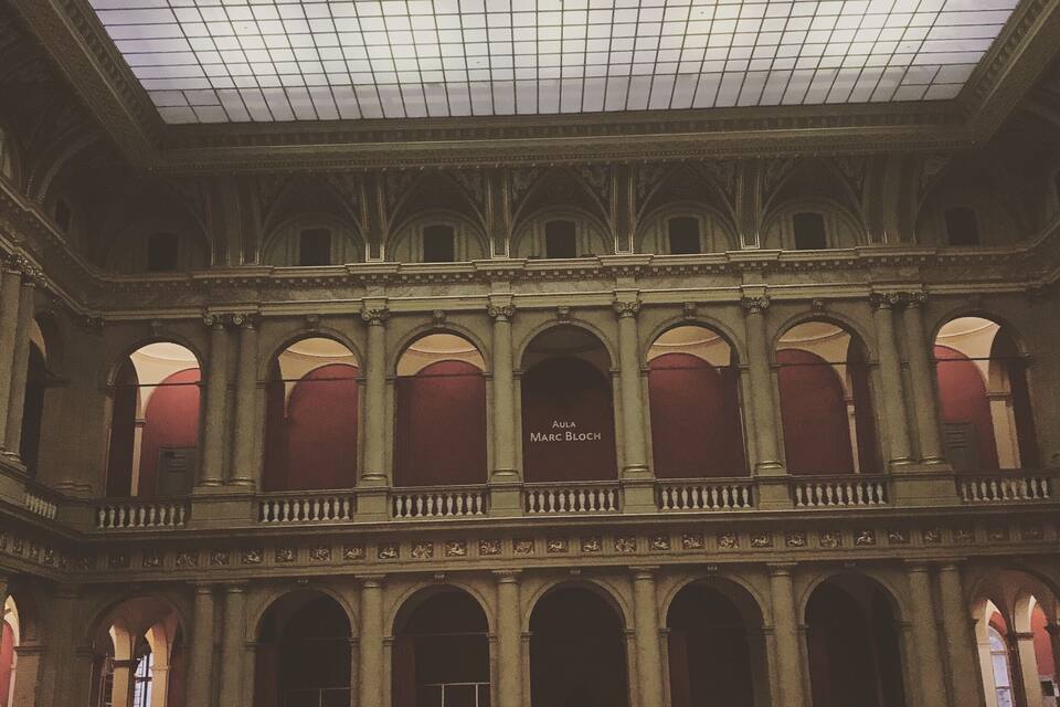 Un intérieur spacieux avec un plafond haut, des fenêtres en arc de cercle et un espace central ouvert.