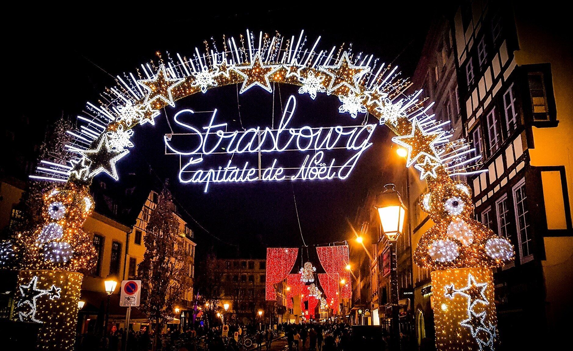 En vackert utsmyckad gatuscen med en neonskylt som visar texten: ”Stroszwag Capitatie de Noet”.