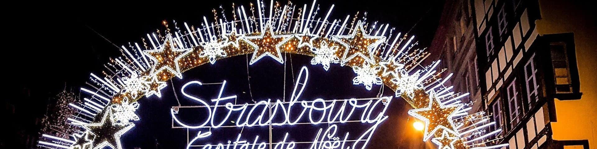 A decorated street scene with a neon sign reading "Stroszwag Capitatie de Noet."