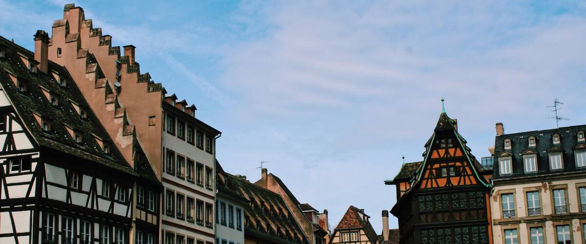 A street lined with historic half-timbered buildings under a clear sky.