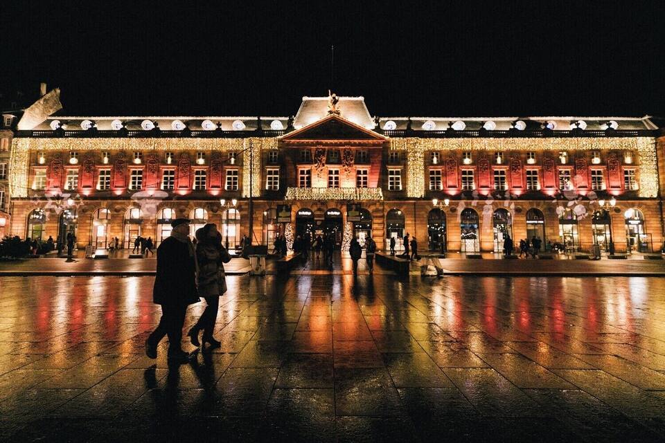 A historic building with illuminated windows and a central entrance.
