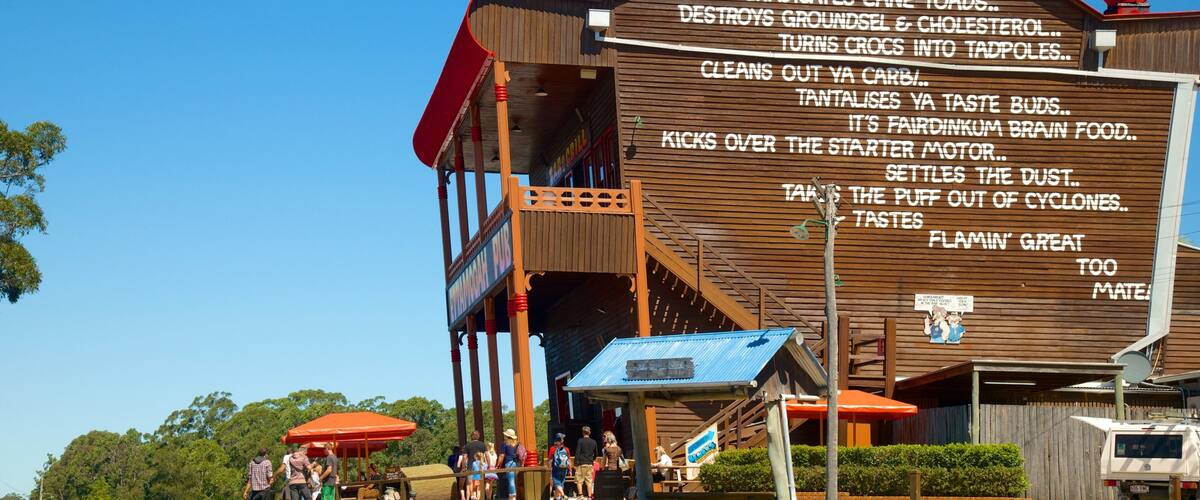 A wooden building with a sign listing various food and drink items.