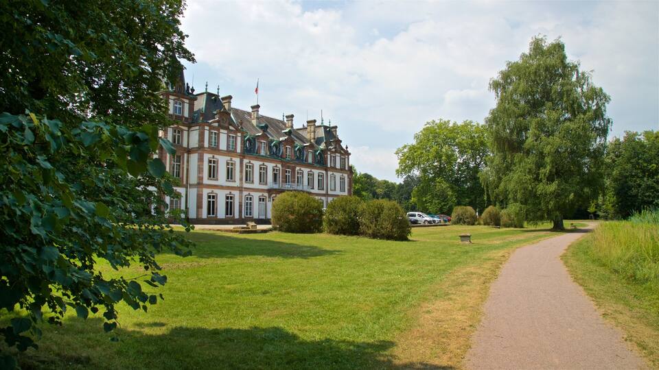 A large, historic building with a well-maintained lawn and a pathway leading to it.
