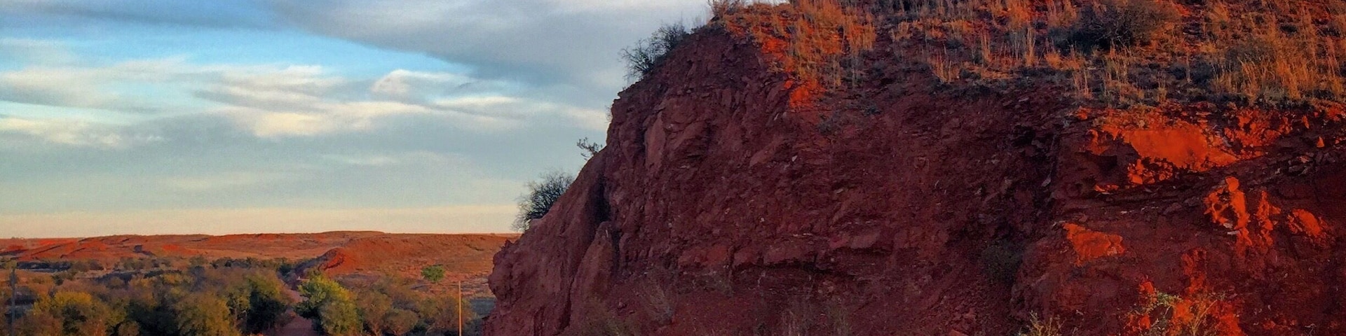 In the evening light, the red rocks glow fluorescent against the bright blue sky.