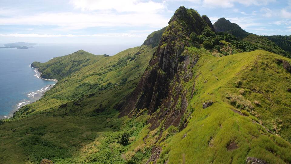 A coastal mountain range with lush green hills and a coastline.