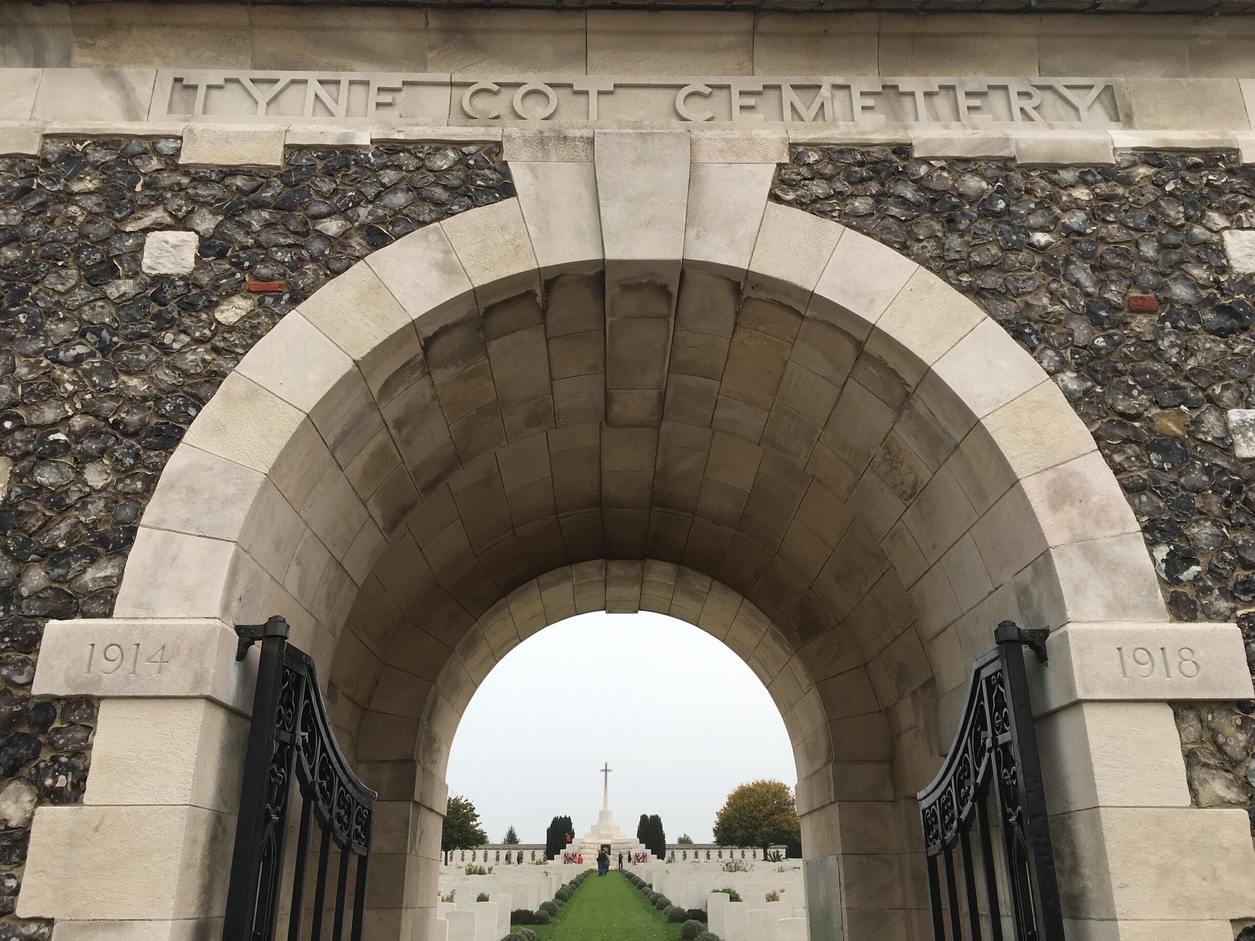 Una entrada arqueada a un cementerio con la inscripción "Lynn Cot Cemetery" y las fechas "1914" y "1918" en el arco.