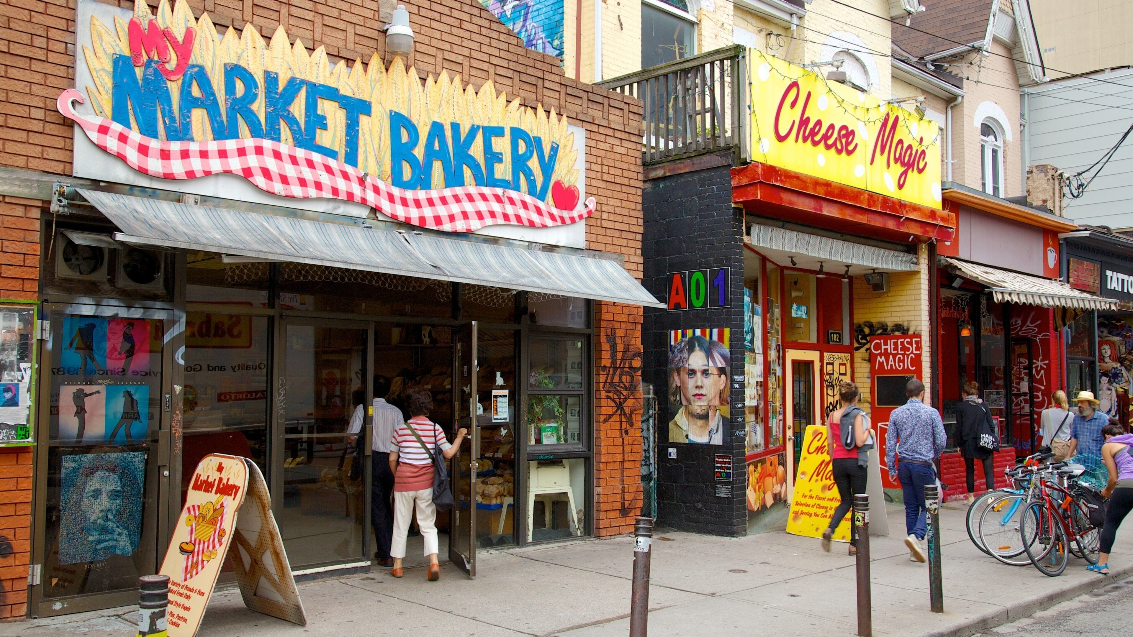 Market Bakery and Cheese Magic storefronts with people walking by.