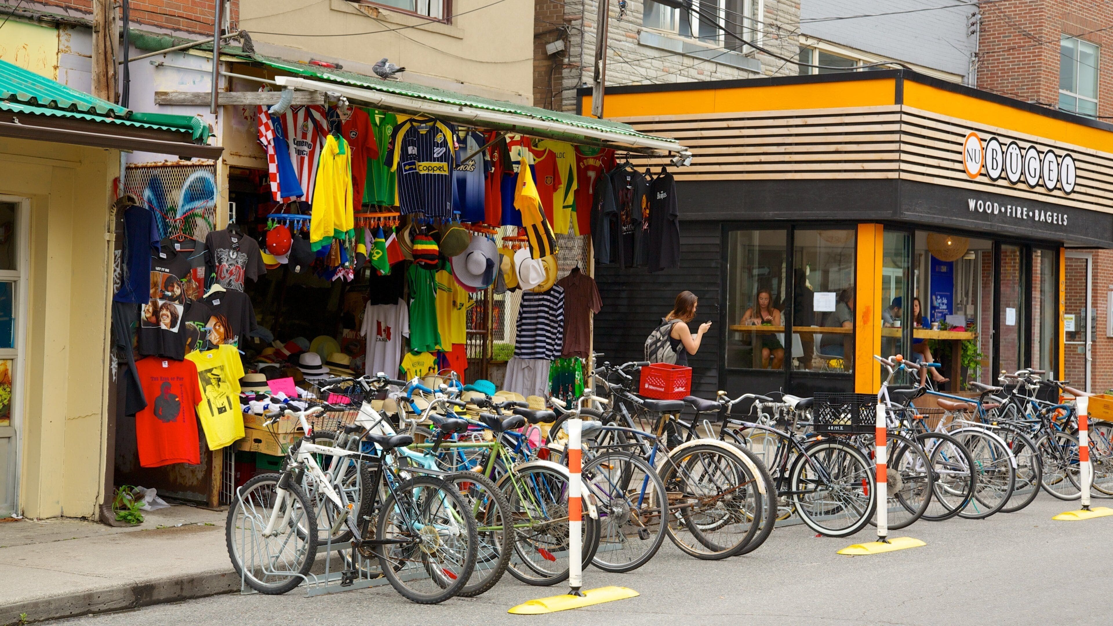 A street with a variety of colorful clothing and hats displayed outside a store.