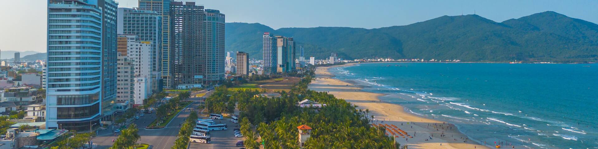 Aerial sunset view of Da Nang coastline. My Khe beach seafront with high-rise hotels and skyscrapers in the golden sand beach