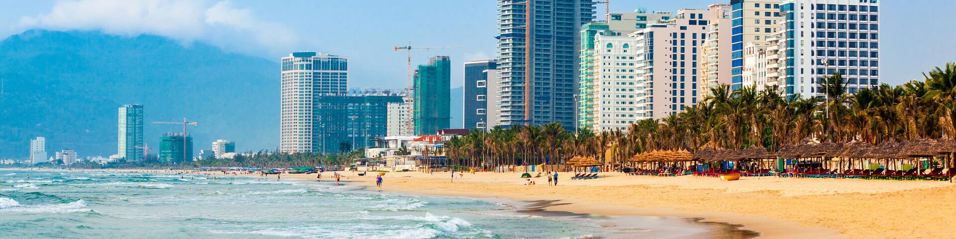 A beach with a city skyline in the background.
