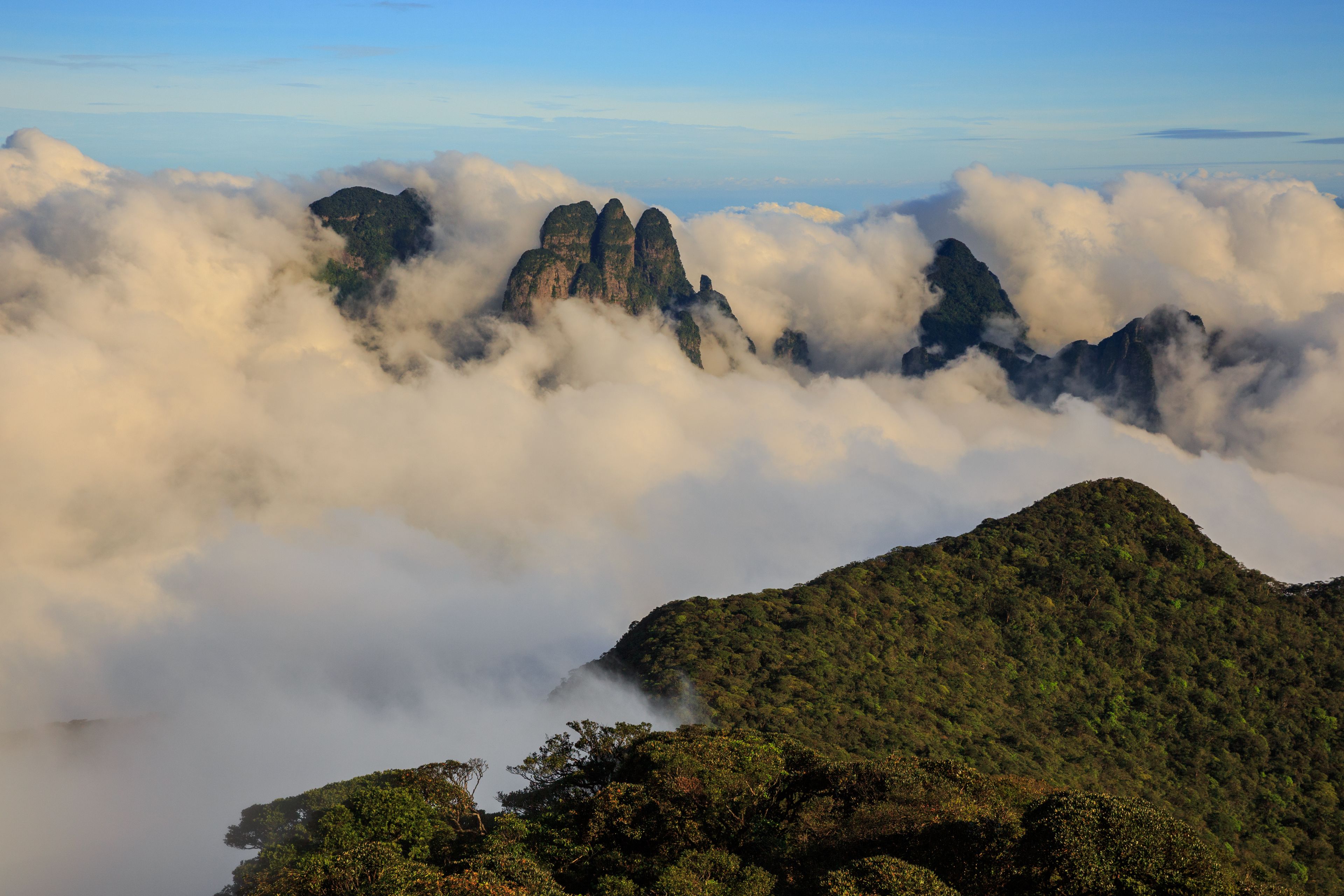 A mountainous landscape with dense cloud cover and rugged peaks.