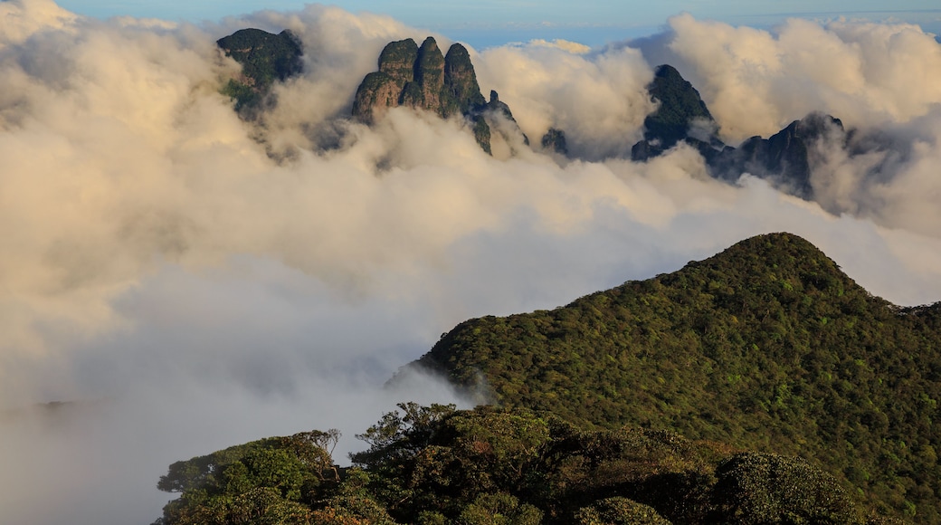A mountainous landscape with dense cloud cover and rugged peaks.