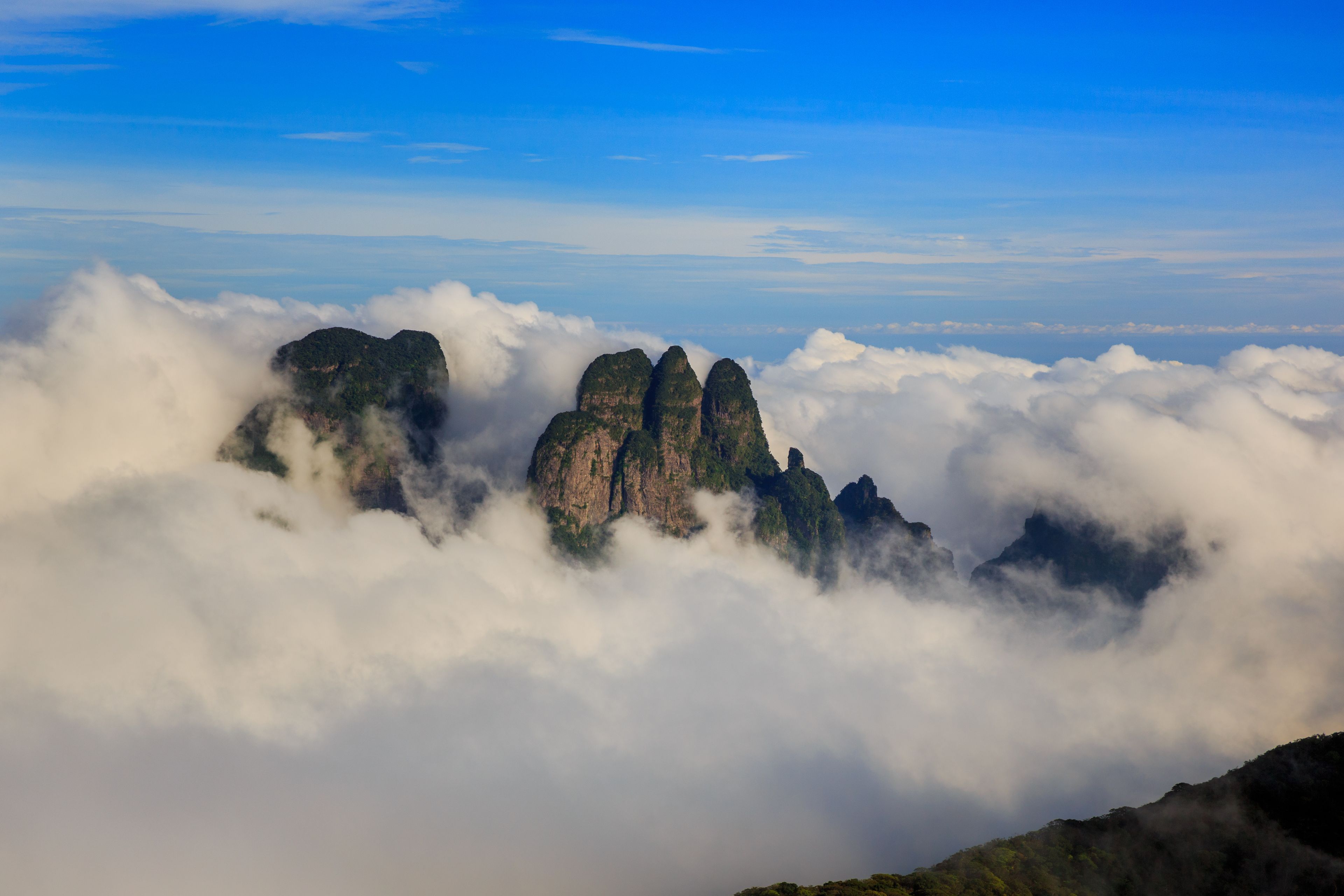 A mountain range with prominent peaks partially obscured by clouds.