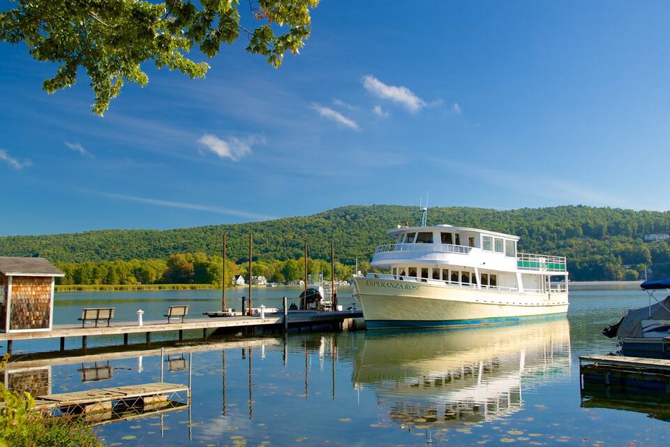 A white boat named 'Esperanza Rose' docked at a pier with a forested hill in the background.
