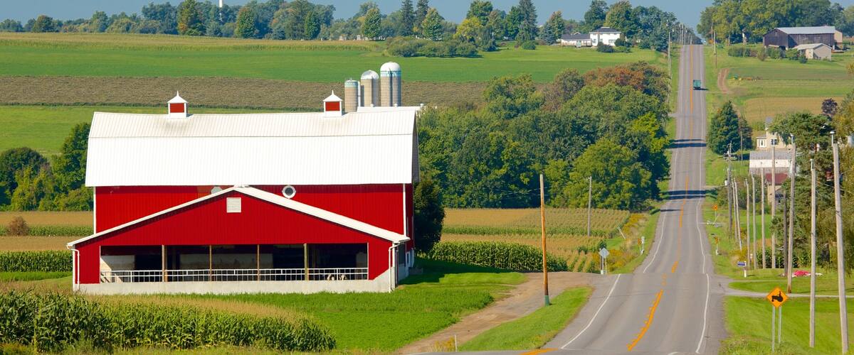 A red barn, a road, and green fields.