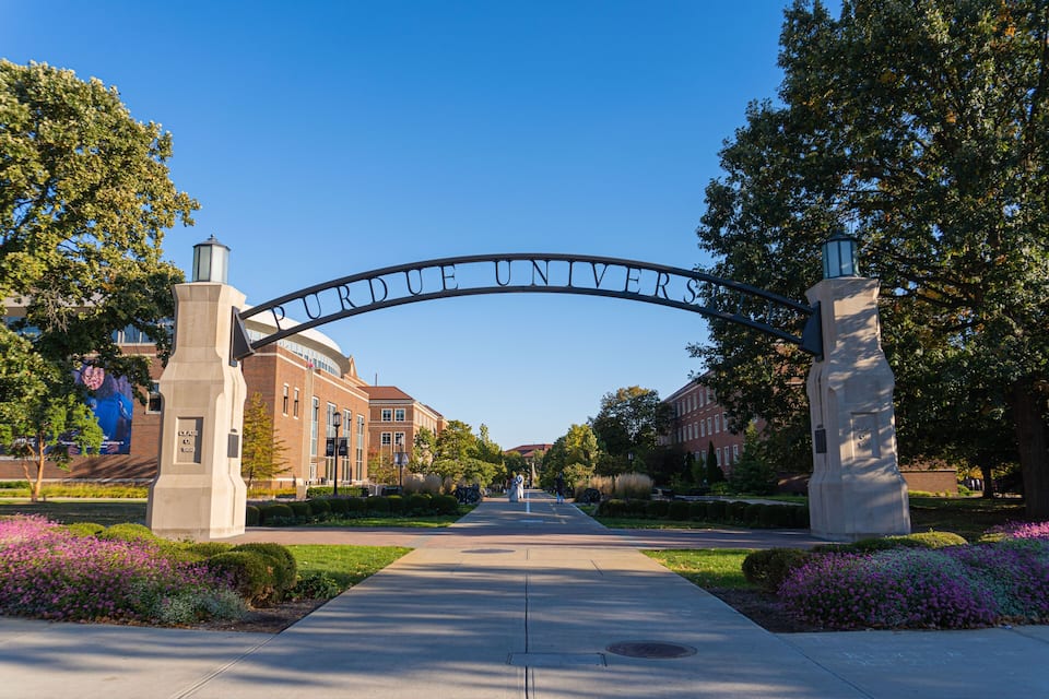 Un arc d’entrée marquant l’accès à l’université, portant l’inscription « PURDUE UNIVERSITY », et un chemin menant aux bâtiments.