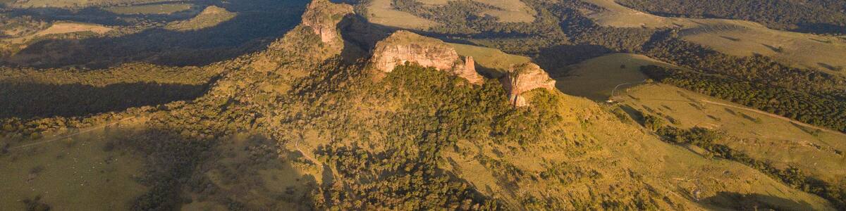 A mountainous landscape with a prominent rocky peak and surrounding valleys.