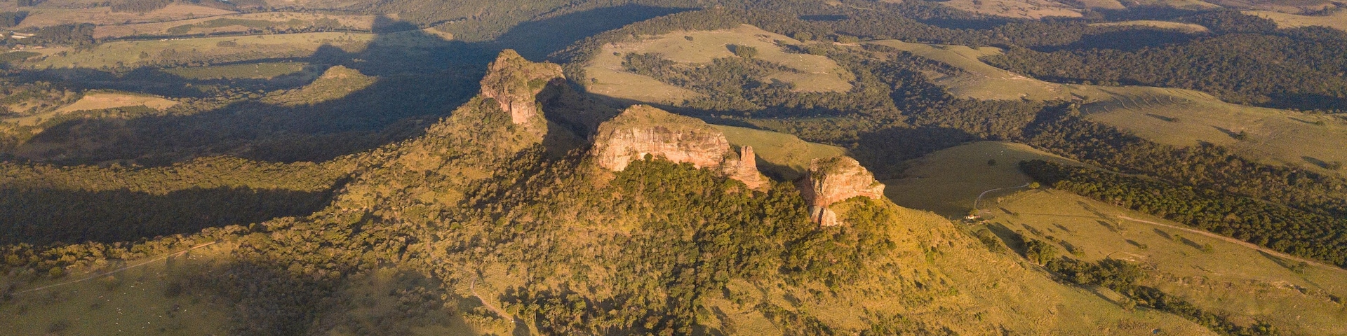 Un paisaje montañoso con un pico rocoso destacado y valles circundantes.
