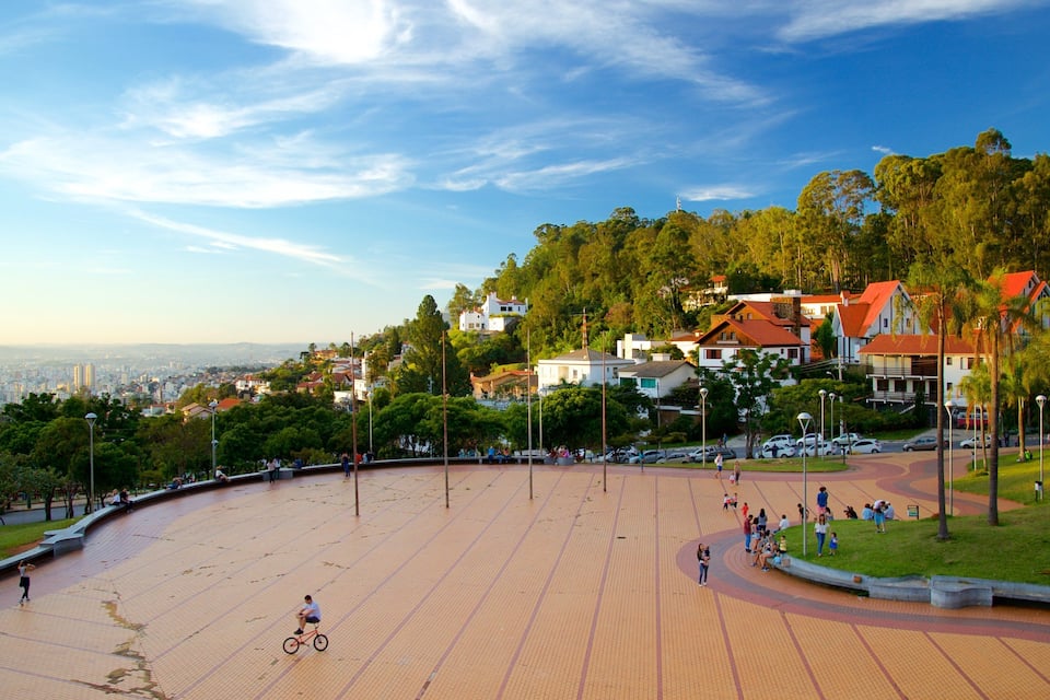 A large open plaza with a cyclist, surrounded by greenery and residential buildings.