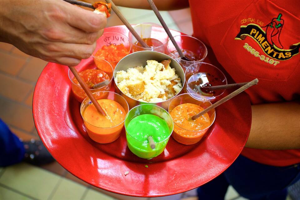 A person serving colorful drinks from a tray.