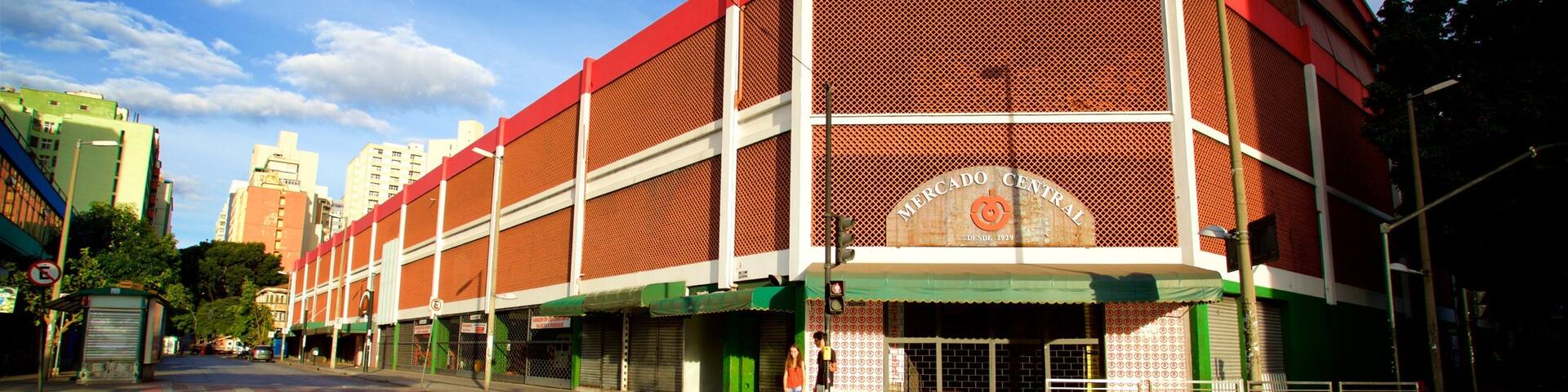 A large red building with a sign that reads "Mercado Central" and a green awning.