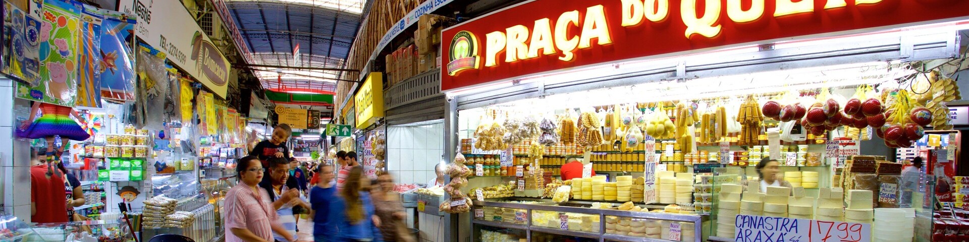 Un mercado animado con una destacada tienda de queso 'Praça do Queijo'.