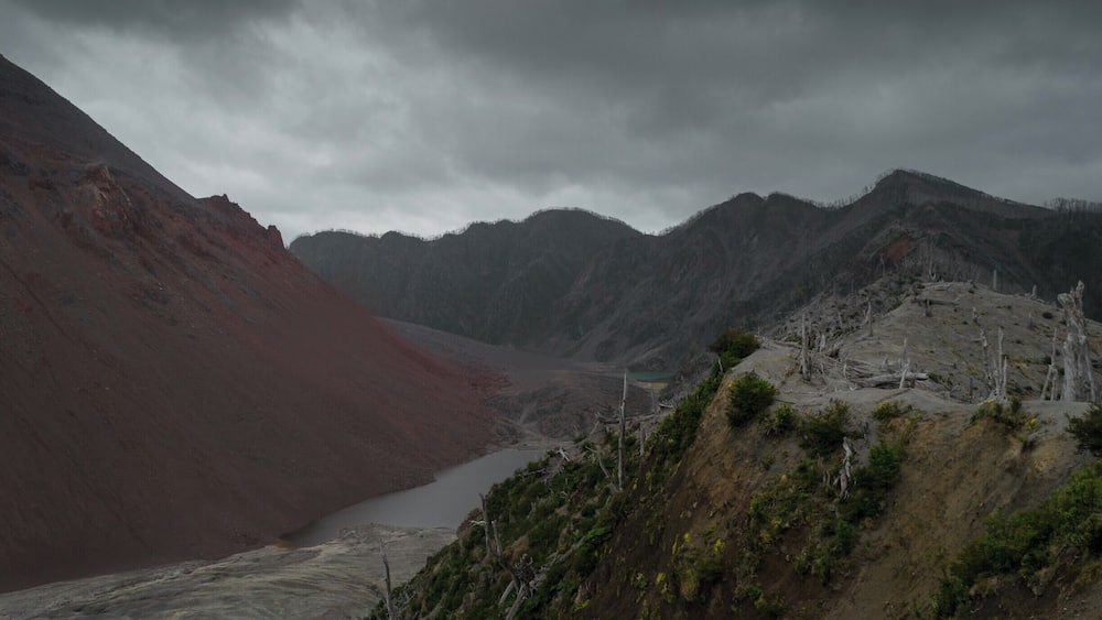 A rugged mountainous landscape with a river flowing through a valley.