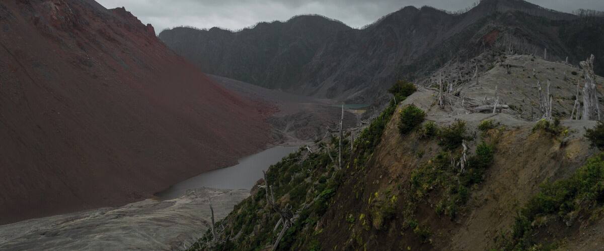 A rugged mountainous landscape with a river flowing through a valley.