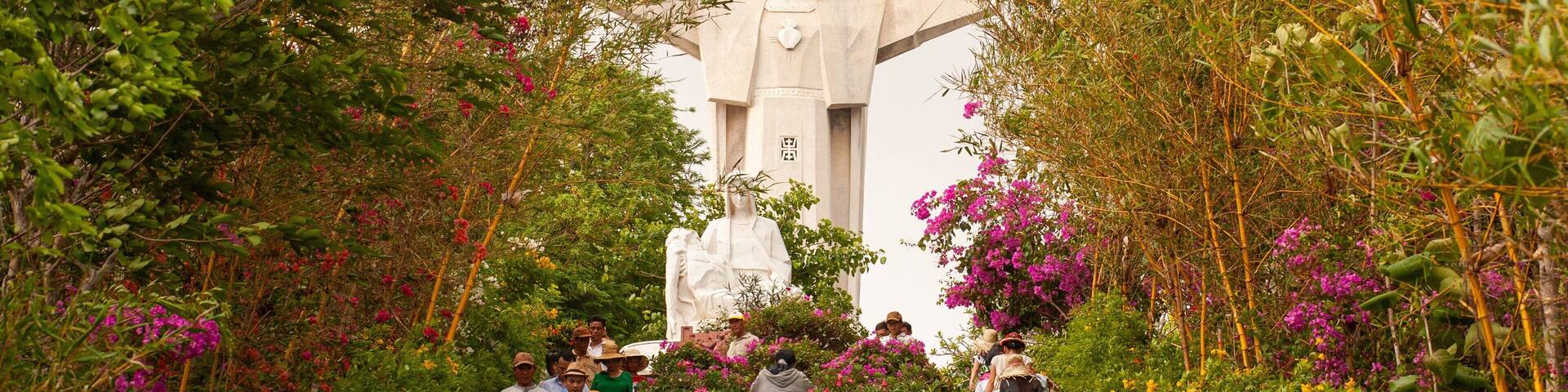 Tuong Dai Chua Kito Vua showing a garden, a statue or sculpture and wildflowers