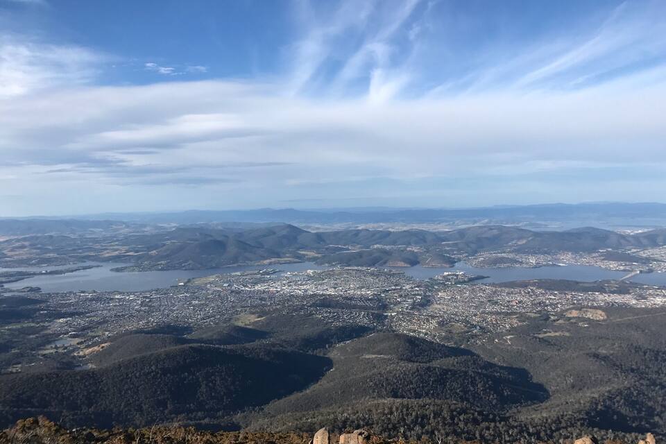 A panoramic view of a city surrounded by hills and mountains, with a river running through the city.