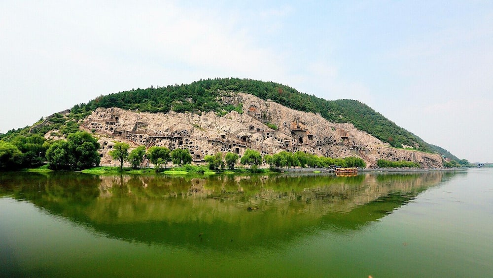 A serene lake with a rocky island featuring ancient ruins and lush greenery.