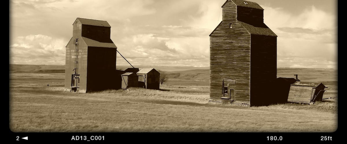 Two grain elevators in a rural landscape.