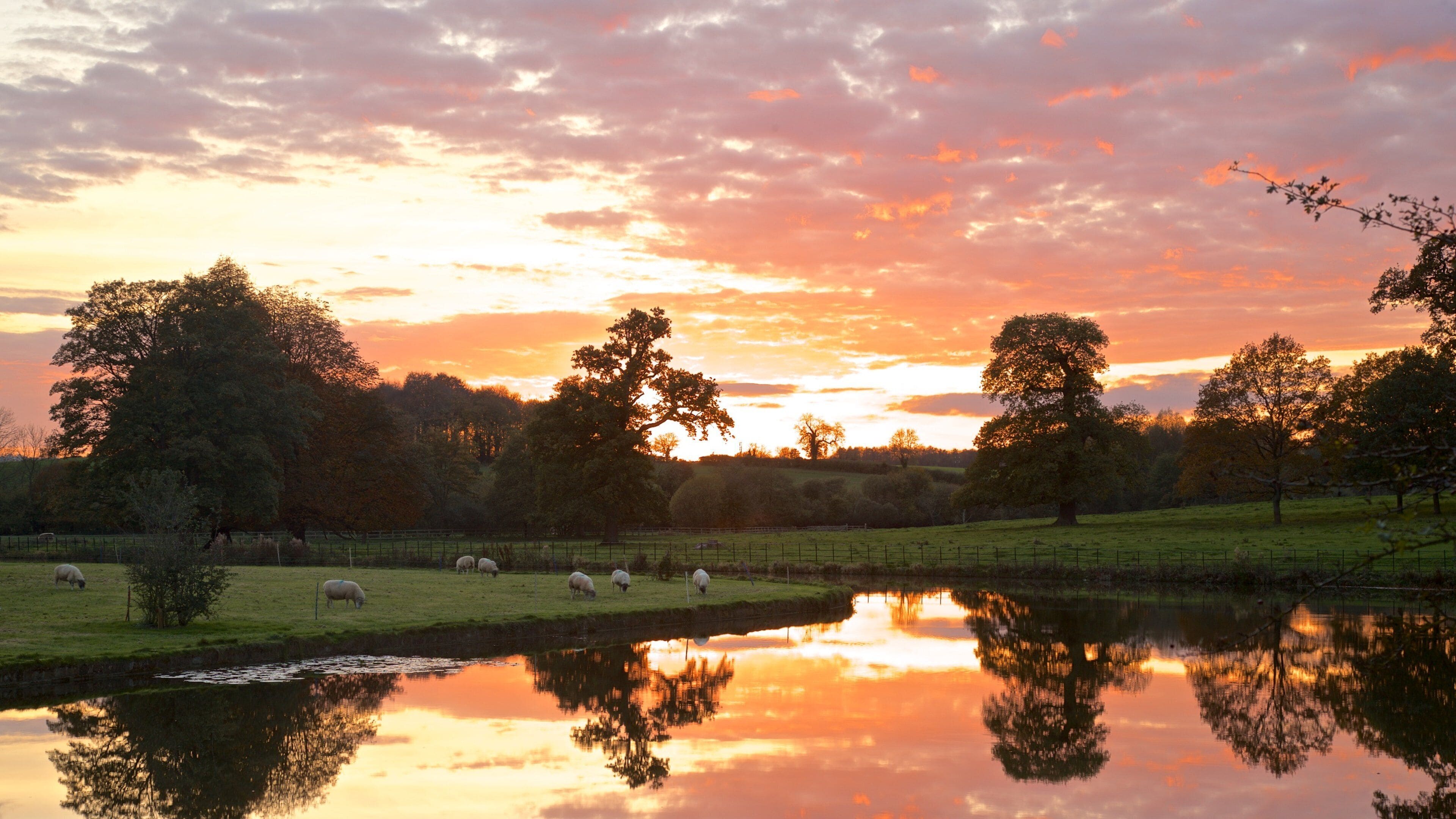 Broughton Castle featuring a sunset, landscape views and farmland