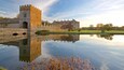 Broughton Castle which includes a sunset, a lake or waterhole and a castle