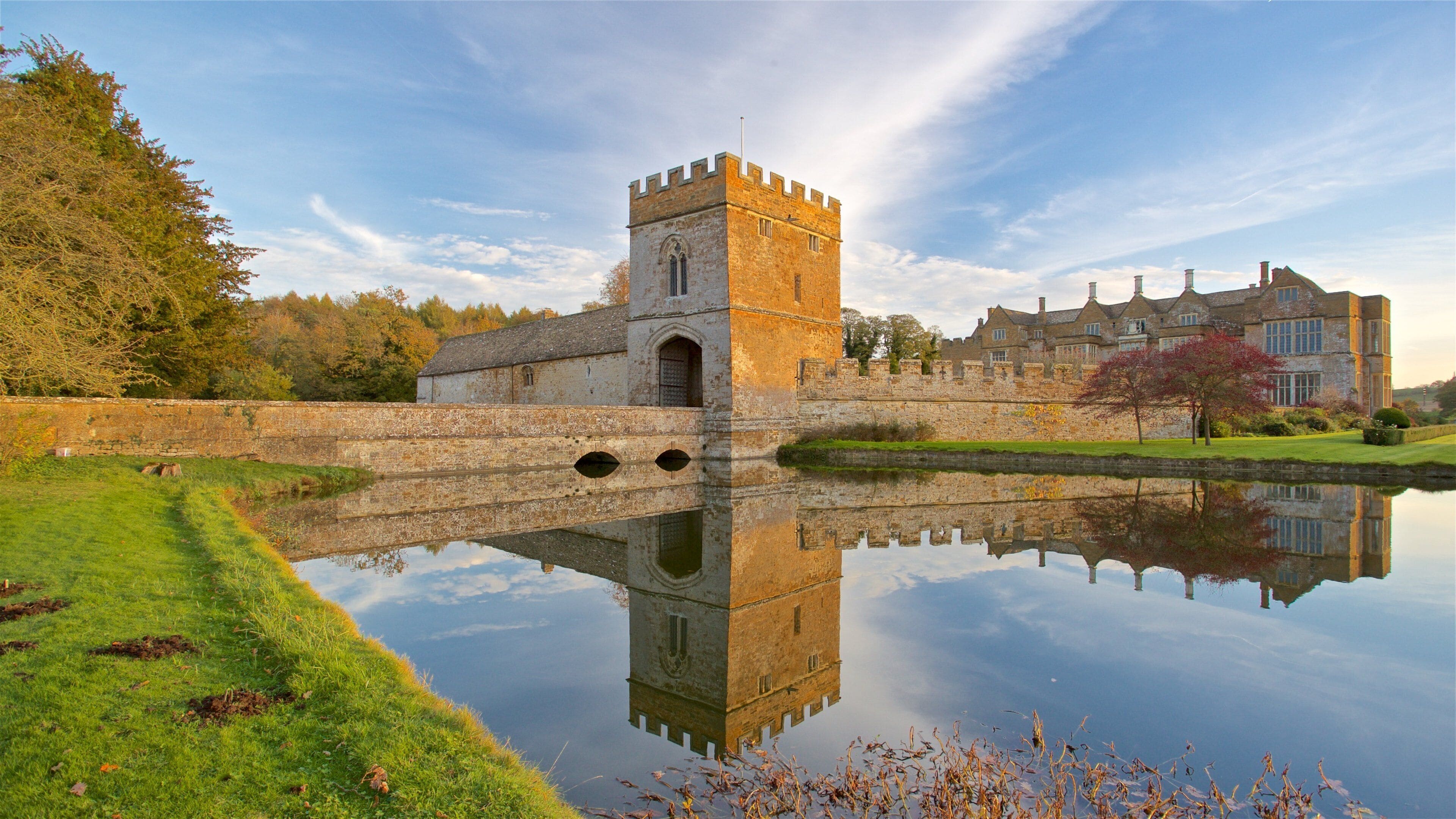 Broughton Castle showing a sunset, a lake or waterhole and château or palace
