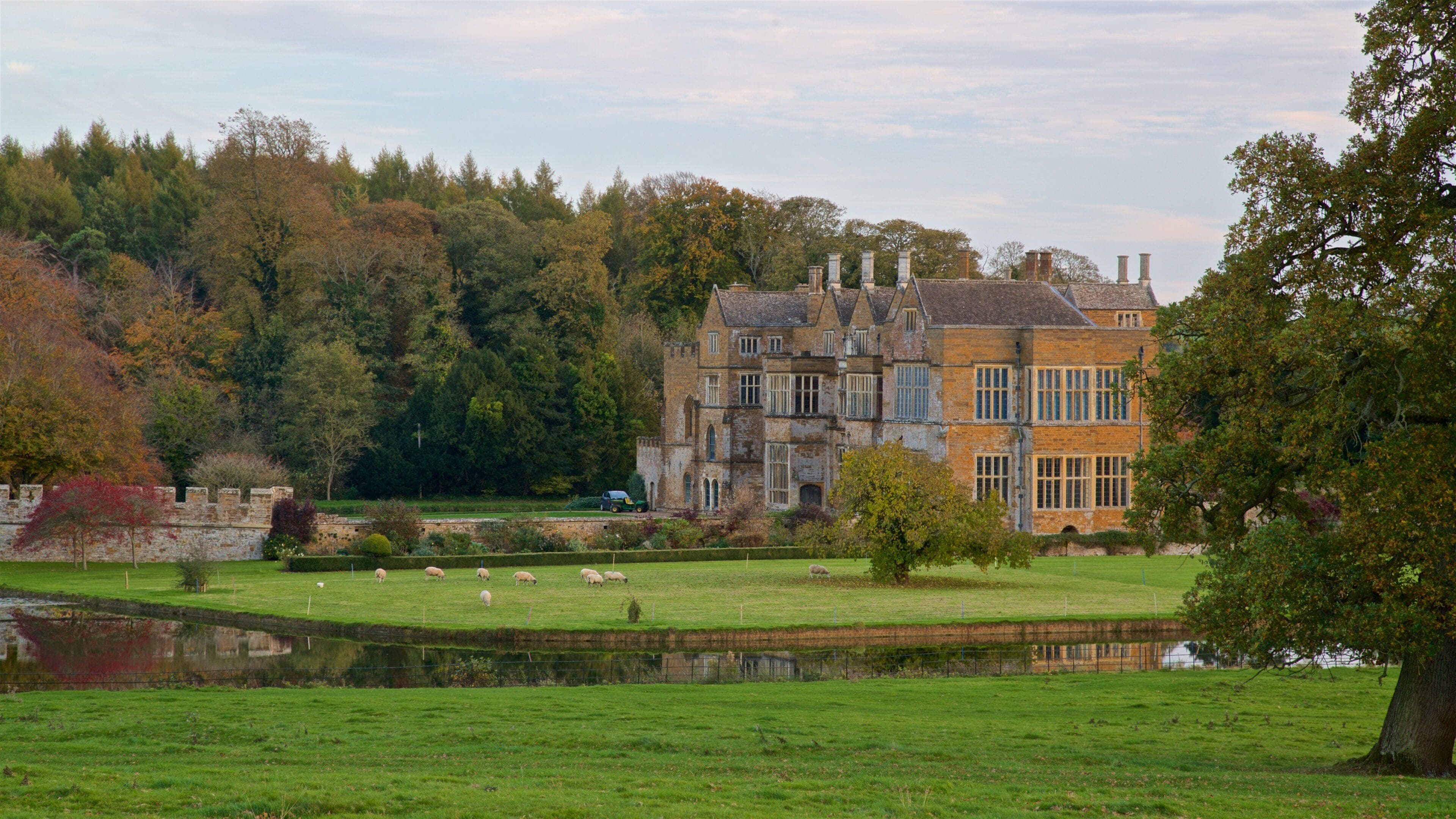 Broughton Castle featuring a river or creek, heritage architecture and farmland