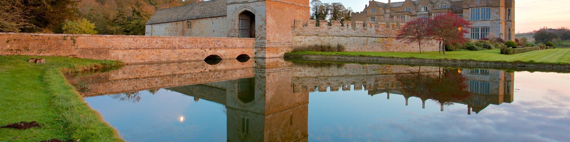 Broughton Castle featuring a sunset, a lake or waterhole and heritage architecture