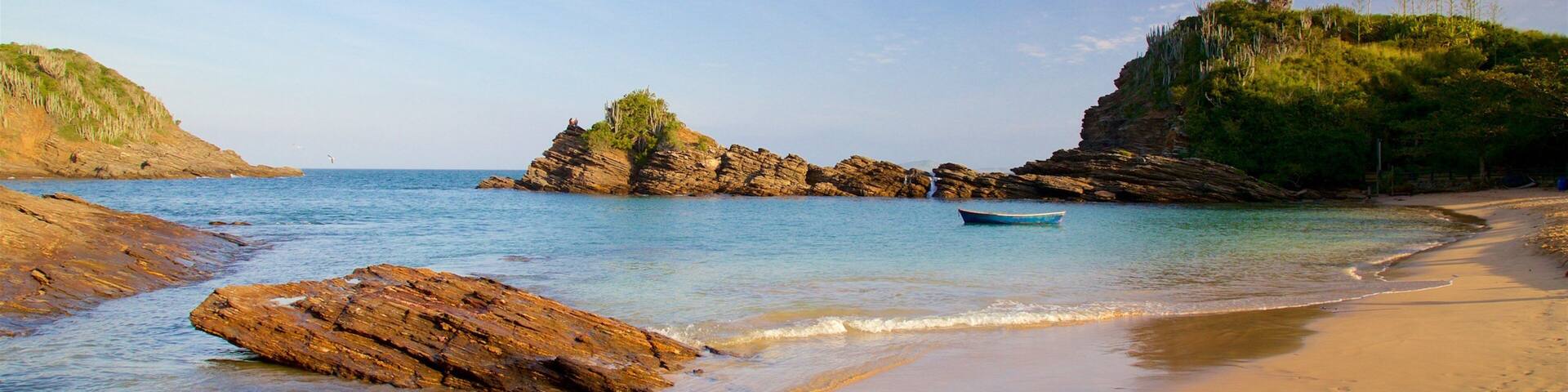 Ferradurinha Beach featuring a sandy beach, rocky coastline and a sunset