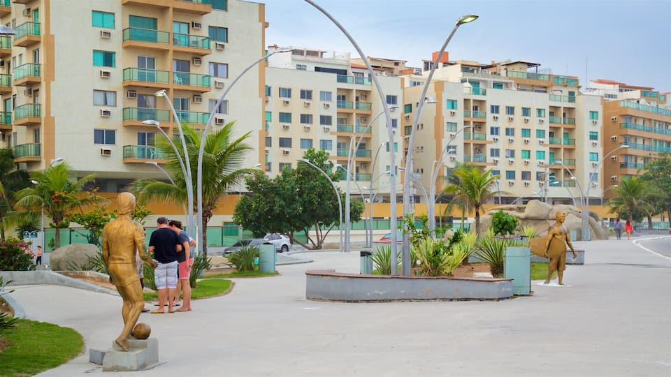Praça das Águas som viser statue eller skulptur og hage i tillegg til par