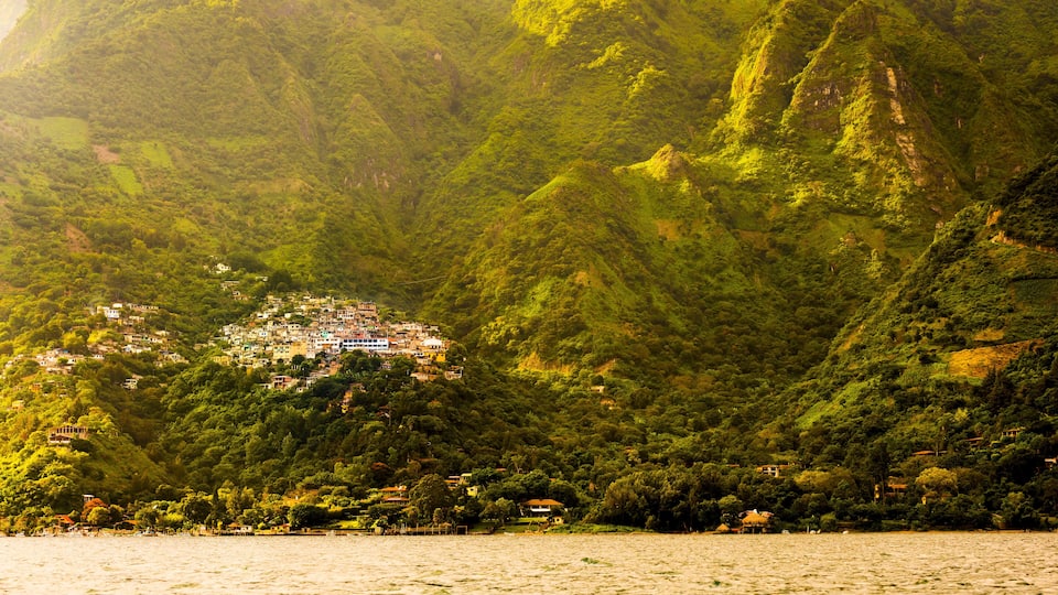 A coastal village nestled in a lush, mountainous landscape.