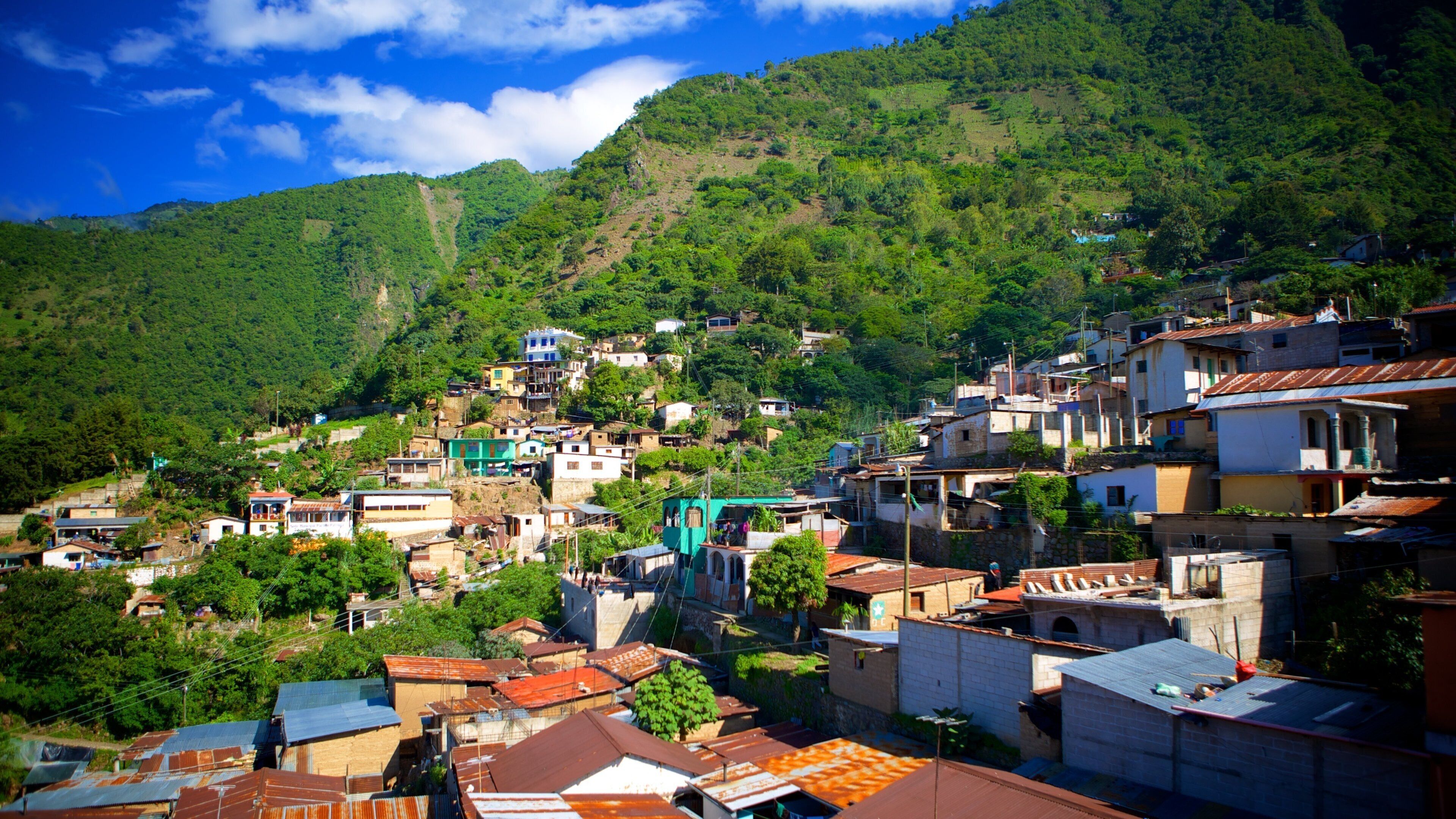 A hillside village with terraced houses and lush greenery.