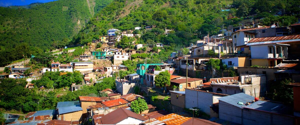 A hillside village with terraced houses and lush greenery.