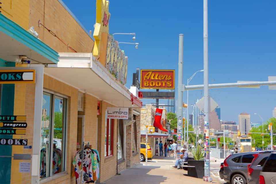 A street with various shops including a bookstore, a jewelry store, and a boot store.