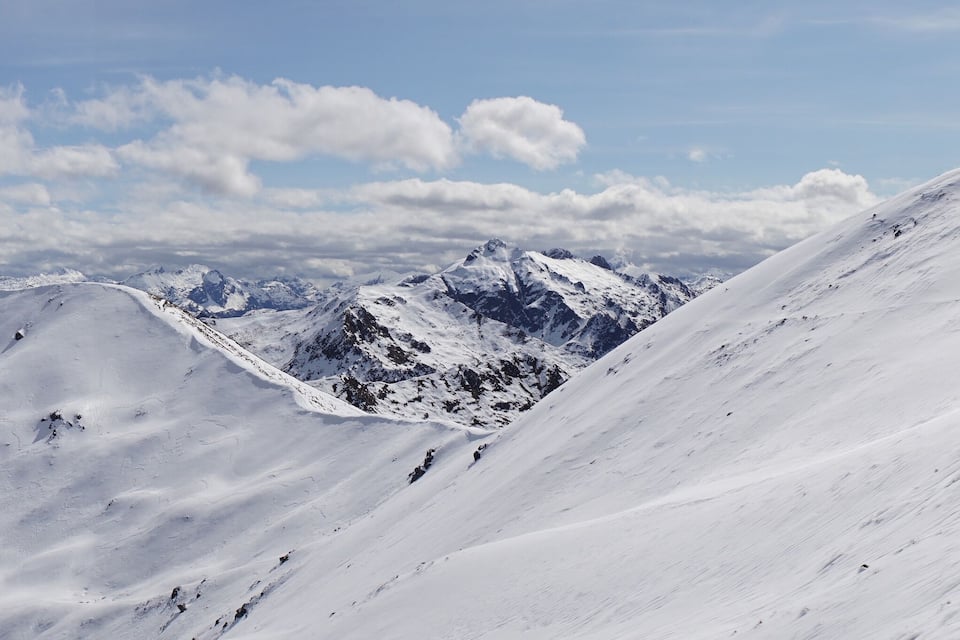 Un sommet de montagne enneigé, sous un ciel dégagé.