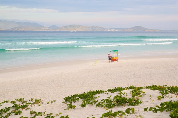 Une plage avec un chariot aux couleurs vives et une personne au loin.