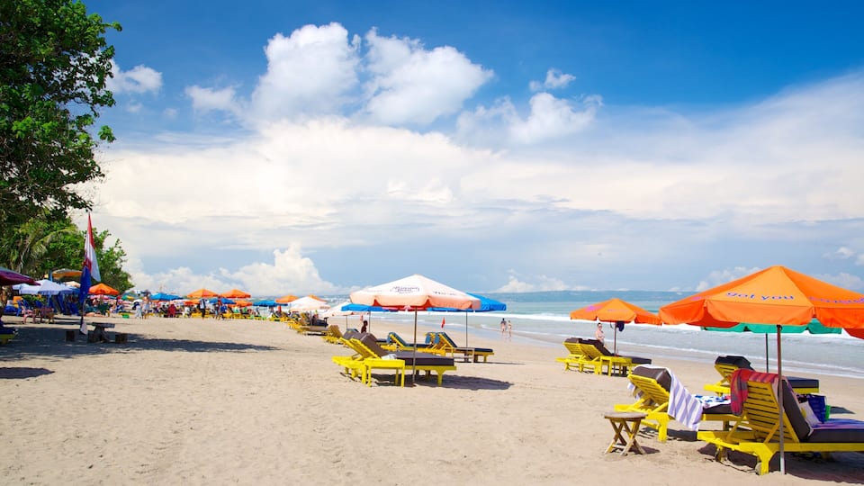 A beach with yellow lounge chairs and orange umbrellas.