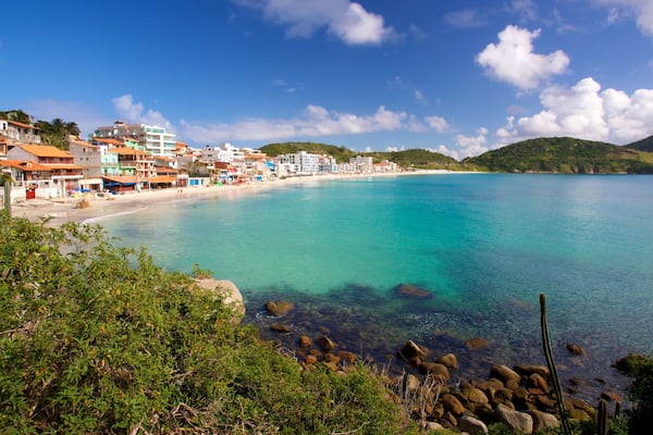 Eine Küstenstadt mit klarem, türkisblauem Wasser, einem Sandstrand und Häusern entlang der Uferlinie.