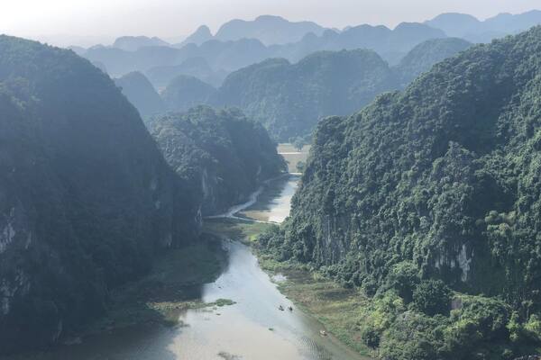 A river winding through a canyon with dense green foliage on steep cliffs.