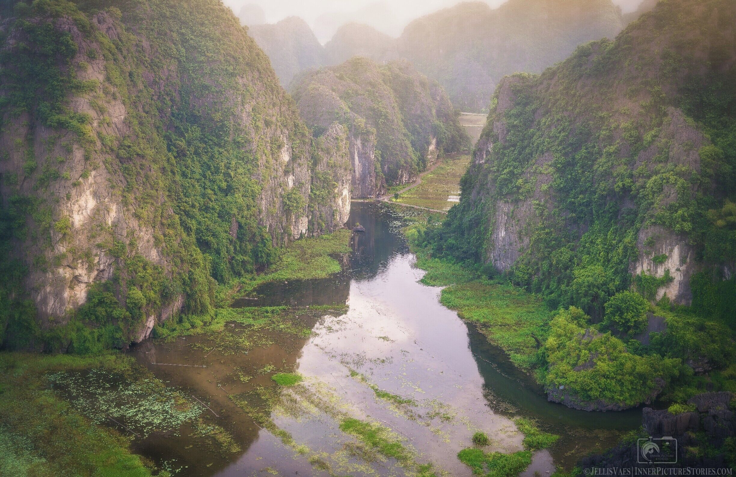 A river winding through a lush valley with steep, forested cliffs.