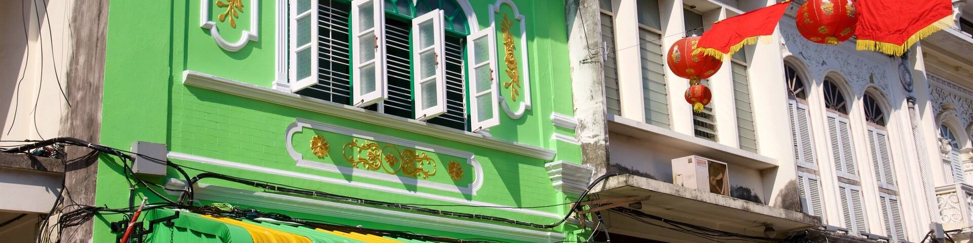 A green building with ornate decorations, a yellow awning, and red lanterns.
